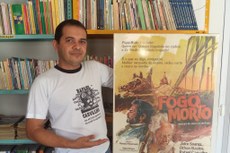 Jocelino Tomaz segura cartaz do filme "Fogo Morto", que teve no elenco o ator Rafael de Carvalho 