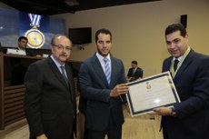 Procurador-geral do Estado, Gilberto Carneiro,recebendo a homenagem das mão do diretor do Foro da JFPB, juiz Federal Bruno Teixeira, e do presidente do TRF-5, desembargador Federal Manoel Erhardt.